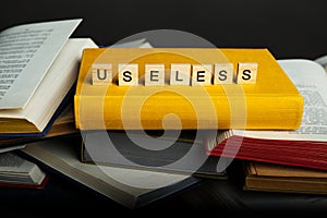 The concept of useless knowledge. Useless - word from wooden blocks