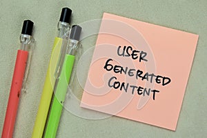 Concept of User Generated Content write on sticky notes isolated on Wooden Table