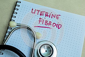 Concept of Uterine Fibroid write on book isolated on Wooden Table photo