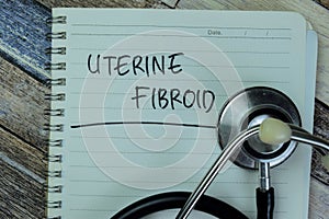 Concept of Uterine Fibroid write on book with stethoscope isolated on Wooden Table photo