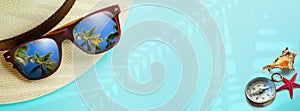 concept vacation and summer travel banner. Happy holidays on tropical sea beach. Panama hat, compass, sunglasses with a reflection
