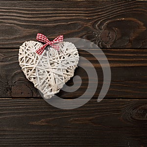 Concept of Valentine`s Day. Wicker hearts on dark wooden backgro