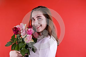 The concept of Valentine's Day and Women's Day. Happy young girl holding a bouquet of roses.