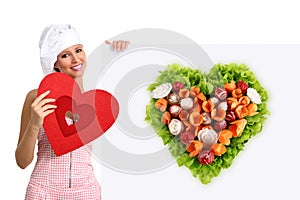 Concept vegetarian diet chef woman pointing billboard salad heart shape