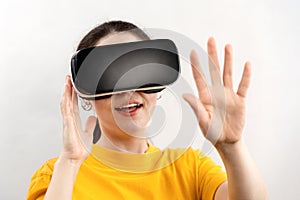 The concept of virtual reality. Close up portrait of a young amazed woman wearing virtual reality glasses, holding out her hands,