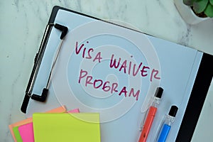 Concept of Visa Waiver Program write on paperwork isolated on Wooden Table