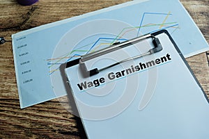 Concept of Wage Garnishment write on paperwork isolated on wooden background photo