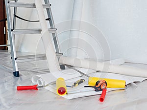 Concept of wallpapering in the house. Close-up tools for wallpapering lie on the floor.