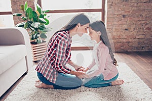 Concept of warm close and trusting relationship in family. Mother dressed in checkered shirt and jeans and charming girl with lon