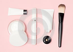 Concept of a white and black cosmetic supplies. Top view on pink background