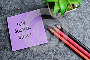 Concept of Wir Suchen Dich write on sticky notes isolated on Wooden Table photo