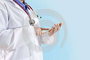 Concept of woman doctor holding and touching screen on smart phone on gradient blue background