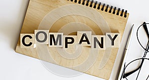 Concept wooden blocks Company on a wooden notepad