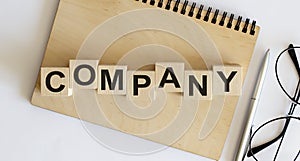 Concept wooden blocks Company on a wooden notepad