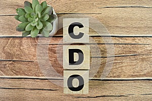 Concept of The wooden Cubes with the word CDO - Collateralized Debt Obligations on wooden background