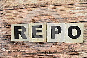 Concept of The wooden Cubes with the word REPO - Repurchase Agreement on wooden background
