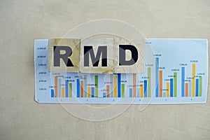 Concept of The wooden Cubes with the word RMD - Requirement Minimum Distributions on wooden background photo