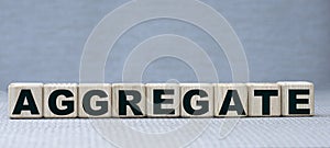 Concept word AGREGATE on wooden cubes on a beautiful gray background