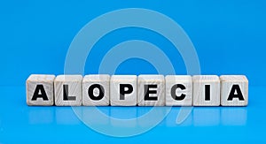 Concept word alopecia on cubes on a blue background