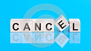 Concept word forming with cube on wooden desk background - Cancel. Blue background