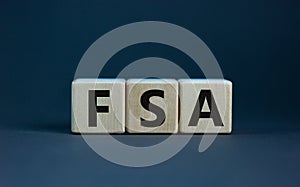 Concept word `FSA - flexible spending account` on cubes on a beautiful grey background. Business concept. Copy space