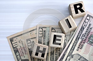 Concept of the word HEIR on cubes on dollar papers photo