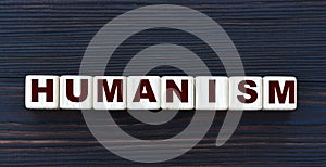Concept word HUMANISM on cubes on a beautiful dark wooden background