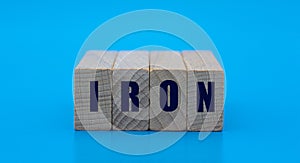 Concept word IRON on cubes on a blue background