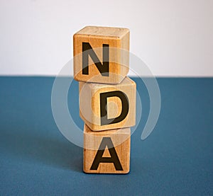 Concept word `NDA` on cubes on a beautiful blue background. Business concept