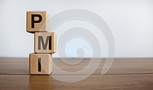 Concept word `PMI` on cubes on a beautiful wooden table. White background. Business concept. Copy space