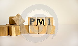 Concept word `PMI` - `Purchasing Managers Index` on wooden cubes on a beautiful white background. Business concept. Copy space
