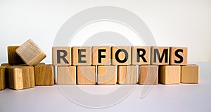 Concept word `reforms` on wooden cubes on a beautiful white background. Business concept. Copy space