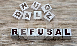 Concept of the word REFUSAL on cubes on a light wooden background