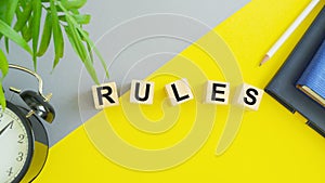 Concept word RULES on wooden cubes on a gray yellow background. Business concept, Top view flat lay