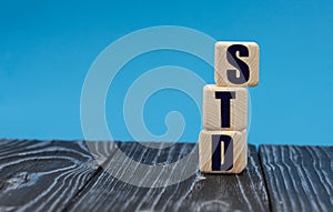 Concept word STD on wooden cubes on a blue background