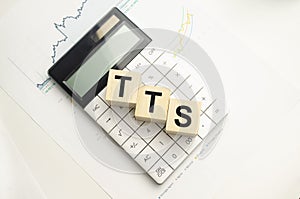 Concept word tts on wooden blocks on beautiful background from green flower photo