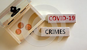 Concept words `COVID-19 crimes` on blocks on a beautiful white background, small chest with coins. Beautiful white background,