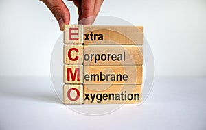 Concept words `ECMO, Extra Corporeal Membrane Oxygenation` on cubes and blocks on a beautiful white background. Male hand. Copy photo