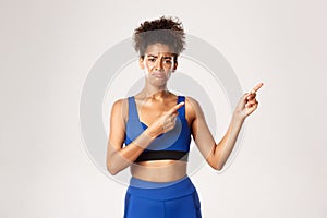 Concept of workout and fitness. Miserable and disappointed african-american female athelte crying, pointing fingers at