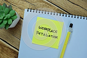 Concept of Workplace Retaliation write on sticky notes isolated on Wooden Table