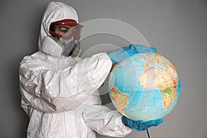 Concept: world viral crisis. Woman in lab coat, nitrile gloves, goggles, face mask, and NBC suit for covid-19 coronavirus, sitting