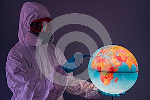 Concept: world viral crisis. Woman wearing lab coat, nitrile gloves, safety glasses, face mask and NBC suit for covid-19