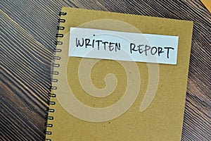 Concept of Written Report write on a book isolated on Wooden Table