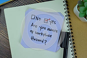 Concept of Are you aware of workplace hazard? Yes write on sticky notes isolated on Wooden Table