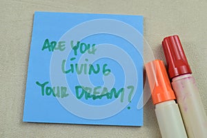 Concept of Are You Living Your Dream write on sticky notes isolated on Wooden Table