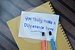 Concept of You Trully Make a Difference Here write on sticky notes isolated on Wooden Table photo