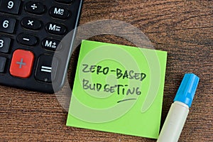 Concept of Zero-Based Budgeting write on sticky notes isolated on Wooden Table photo