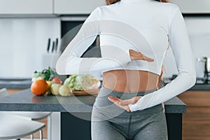 Conception of dieting. Young european woman is indoors at kitchen indoors with healthy food
