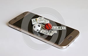 Concepts about online sports betting. The sports balls and money on the smartphone screen. photo