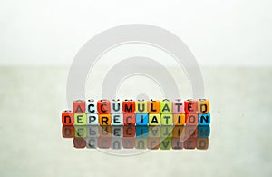 Conceptual of accumulated depreciation in financial statements. Colorful alphabet beads stacked forming the words over dark table